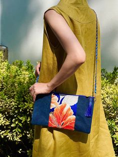 The Kimono Sacoche Crossbody Bags are an original design meant to capture the elegance of kimono obi. The silk incorporated into this bag features a gorgeous orange hibiscus on a rare, deep blue color. With a matching canvas inner lining, useful pockets, and a matching blue tasstle. * * * * * * * * * * * * * * * * * * * * * * * * * * * * * * * *  ~ Authentic kimono obi fabric ~ Thick navy canvas base ~ Sturdy gold colored zipper with matching tassel ~ Chained shoulder strap  ~ African canvas lin Orange Hibiscus, Japanese Summer, Kimono Obi, Unique Handbag, Flower Bag, Luxury Silk, Fabric Bags, Boho Bag, Beaded Bags