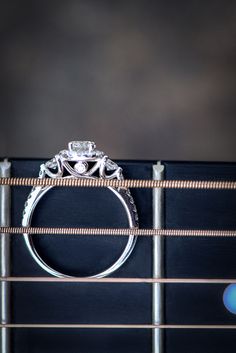 a wedding ring sitting on top of an acoustic guitar