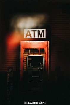 an atm machine in front of a building with the word atm on it's side