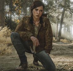 a person kneeling down in the dirt near some trees