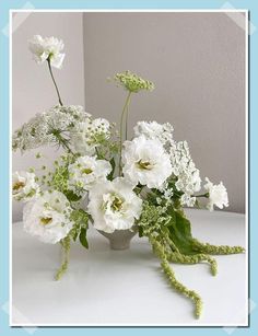 a vase filled with white flowers on top of a table