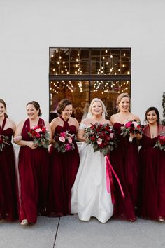 a group of bridesmaids standing in front of a building