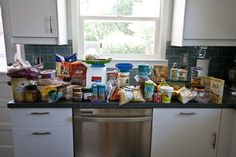 a dishwasher in a kitchen with food on the counter next to it and a window