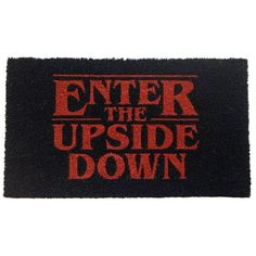 a black door mat with the words enter the upside down printed in red on it