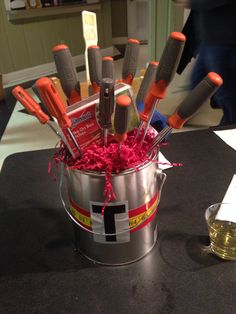 a bucket filled with lots of knives on top of a table