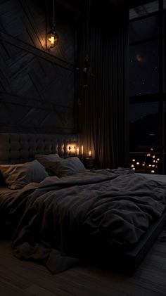 a bed with pillows and blankets in a dark room next to a window at night