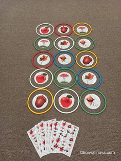 several pieces of paper with apples and leaves on them sitting next to each other in the middle of a table