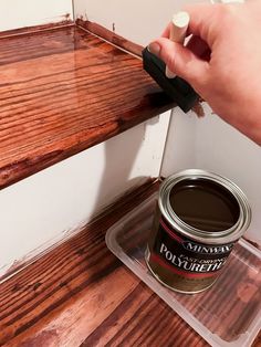 someone is painting the wood with brown paint