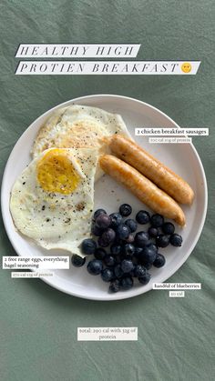 a white plate topped with eggs, sausage and blueberries