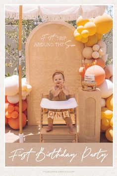 a baby sitting in a high chair with balloons on the wall behind him and an umbrella over it