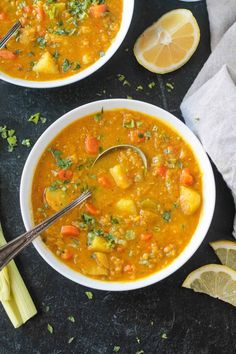 two bowls filled with soup next to sliced lemons