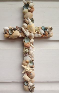 a cross made out of seashells on the side of a building