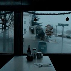 a window view of a street with christmas lights and decorations on the windowsills