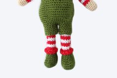 a crocheted green stuffed animal with red and white stripes