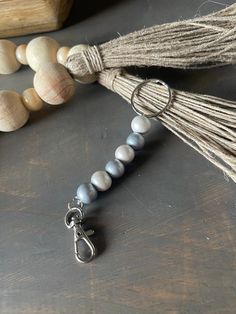 a tasseled beaded necklace on a table next to beads and a book