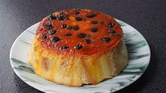 a dessert on a plate with black olives and orange sauce in the center, ready to be eaten