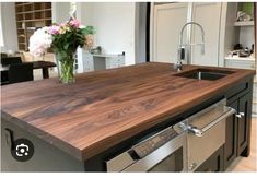 a kitchen counter top that has flowers in a vase on it