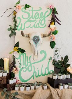 a sign that says stay wild my 3 child on it with flowers and candles in front of it