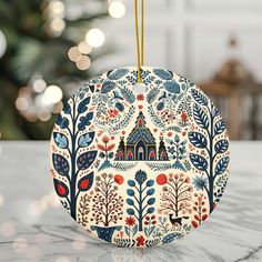 an ornament hanging on a table with a christmas tree in the background