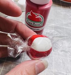 a person holding an object in their hand near a tube of toothpaste and a bottle of mouthwash