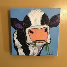 a painting of a black and white cow with green grass in it's mouth