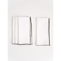 four folded white napkins with black lines on them against a white background, one in the foreground and one in the back ground