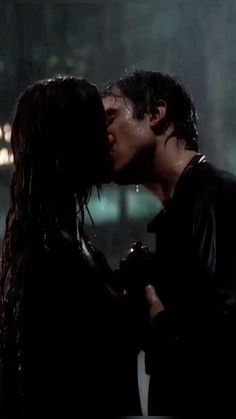 a man and woman kissing in the rain