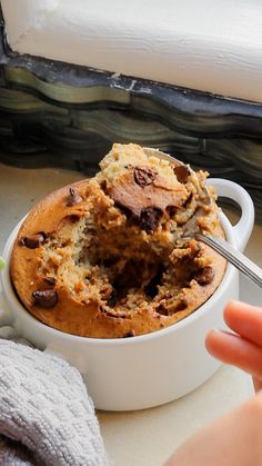 a close up of a bowl of food on a table with a spoon in it