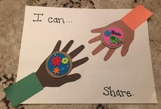 a child's hand holding a button with the word i can share on it