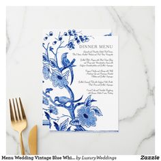 a blue and white menu with flowers on it next to a fork, knife and napkin