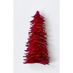 a red christmas tree is hanging on the wall