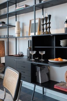 a black shelf with some plates and glasses on it