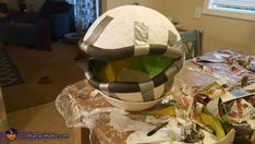 a large white bowl sitting on top of a table covered in plastic wrap and other items