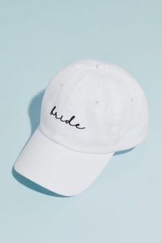 a white hat with the word bride written on it, against a light blue background