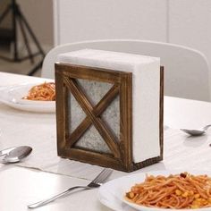 a table with plates, forks and silverware on it that is shaped like an x