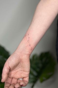 a woman's hand with a small star tattoo on the left side of her wrist