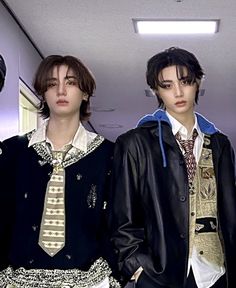 three young men standing next to each other in front of a mirror wearing jackets and ties