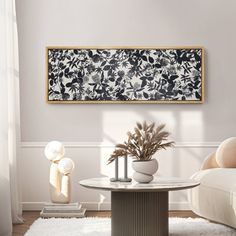 a living room with white furniture and a painting hanging on the wall above the coffee table