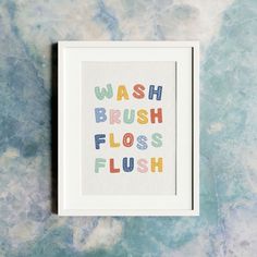 a framed print with the words wash brush floss flush in multicolored letters