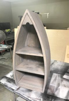 a boat shaped shelf sitting on top of a table