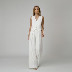 Introducing our Dove Silk Crepe Pants, a statement of luxurious comfort and timeless style. Tailored from white silk crepe with a wide-leg cut, they feature expertly placed darts that contour the waist and flatter the silhouette. The pressed crease detail offers a touch of refinement, elevating the overall look with understated polish. A concealed zipper and hook fastening in the front ensures a seamless finish, while the inclusion of pockets adds a practical yet chic element to the ensemble.  M Modern White Wide Leg Pants For Formal Wear, Modern White Wide Leg Pants For Formal Occasions, Modern White Formal Wide Leg Pants, Elegant Tailored White Wide Leg Pants, White Wide Leg Pants For Summer Evenings, Chic Wide Leg Pants For Summer Weddings, Elegant Wide-leg Wedding Pants, Classic White Evening Pantsuit, Elegant White Wide Leg Pants