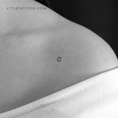 the back of a woman's stomach with a small c tattoo on her left side