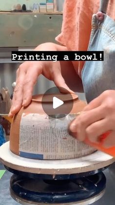 a person is making a bowl out of an old book