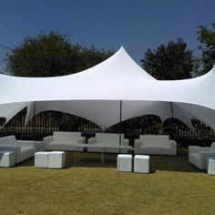 a large white tent with couches and tables under it