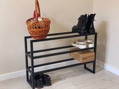 there is a shoe rack with two pairs of shoes on it and a basket next to it