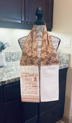 a brown and white scarf sitting on top of a wooden stand next to a counter