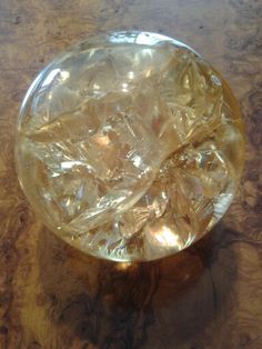 a glass bowl with ice cubes in it on a wooden table top, viewed from above