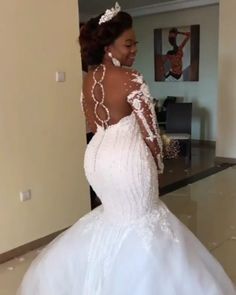 a woman in a white wedding dress is walking through the room with her hand on her hip