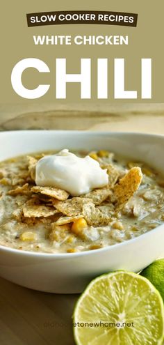 white chicken chili in a bowl with sour cream on top and limes next to it