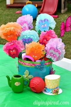 there is a teapot with flowers in it and other decorations on top of the table